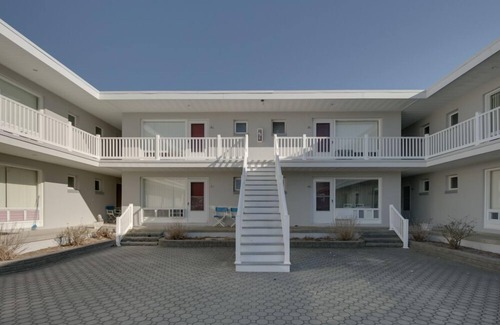 Stone Harbor Condominio | Unidad de eficiencia frontal del primer piso, lado derecho, esquina Mesas y sillas en el patio.