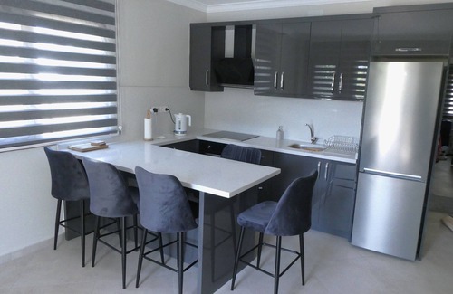 Dalyan City Center Apartamento | Un apartamento en planta baja con piscina compartida en terrenos bien cuidados