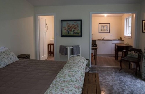 Poukawa Condominio | Un piso sombreado con vista y una pérgola de rosas