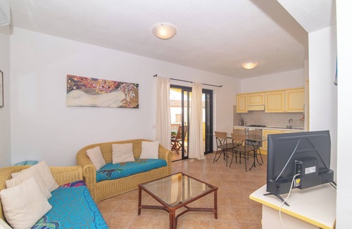 Porto Pozzo Apartamento | Apartamento 'I Mirti 2' con terraza privada, jardín compartido y aire acondicionado.