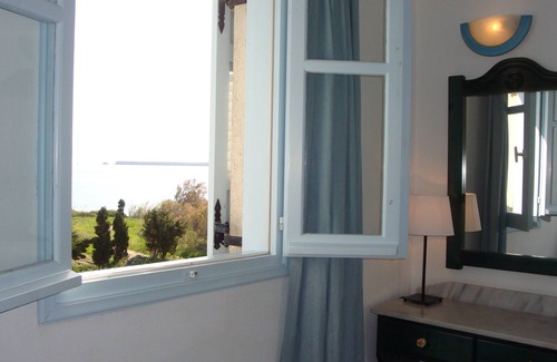 Drios Apartamento | habitación azul y mar con la cara de la ventana con vistas al mar