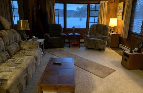Newport Cabina | Cabin is nestled near the Sugar River in a country setting next to a open field.