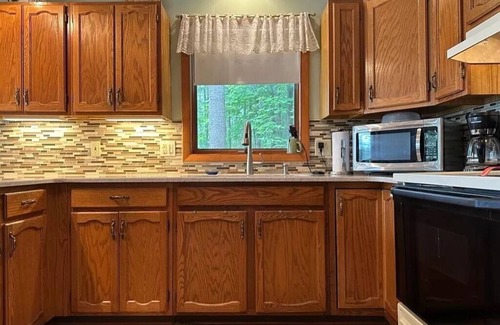 Elmira Cabaña | Cozy beachfront cottage in the woods with walkout basement and wrap-around porch