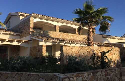 Porto Pino Apartamento | Apartamento con jardín en residencia con piscina.