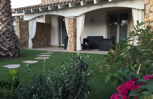 Porto Pino Apartamento | Apartamento con jardín en residencia con piscina.
