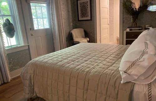 Lenox Cama Y Desayuno | Elegant Carriage House room with a queen bed and private patio.