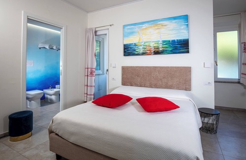 Cala Gonone Cama Y Desayuno | Family room with mountain view terrace and window overlooking the harbor.