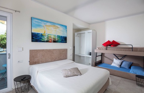 Cala Gonone Cama Y Desayuno | Family room with mountain view terrace and window overlooking the harbor.