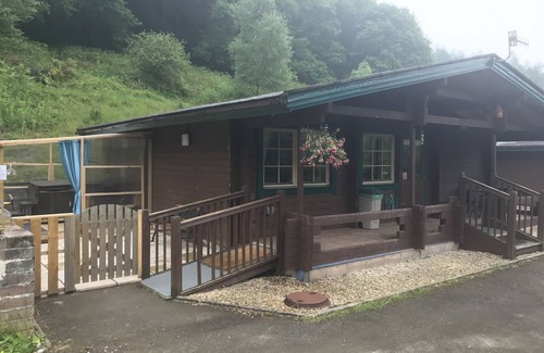 Ynysddu Cabina | Finish Holiday Lodges, ubicado en la ladera boscosa, con vistas a la montaña y al arroyo