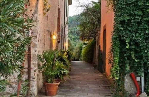 Bacchereto Casa | Flower house, surrounded by greenery, overlooking a large garden.