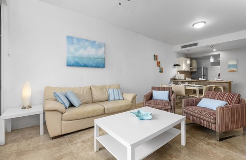 Boegoeroei Condominio | Gated community with resort-style amenities - 2 bedroom, 2 bath with an open concept living room and kitchen. Private balcony overlooks pool area.