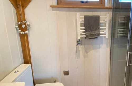 Ham Cabina | Gatehouse Lodge a bespoke Lodge on working farm with a distant sea view and a secluded garden with fire.