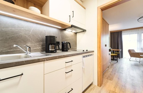 Riedenburg Apartamento | Suite luminosa de estilo rústico con cocina americana.