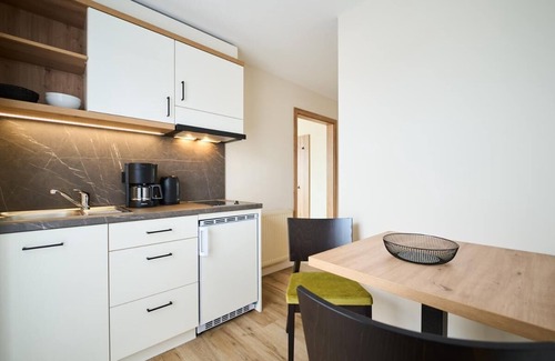 Riedenburg Apartamento | Suite luminosa de estilo rústico con cocina americana.