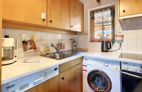 Verbier Apartamento | Living room with fire place, kitchen with vitroceram, dishwasher, microwave and washingmachine, eati