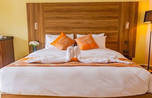 Langata Cama Y Desayuno | Dormitorio moderno y desayuno en el Karen Plains Hotel Nairobi, con balcón