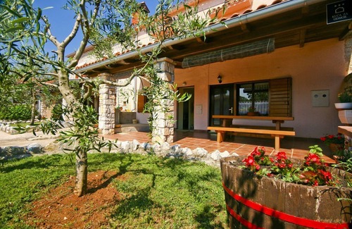 Orihi Casa | Casa rústica de piedra con parasol en una finca vallada