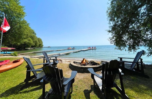 Big Bay Point Cabaña | Shallow Beach Lakefront Cottage perfect with Kayak, Firepit, BBQ + Playground