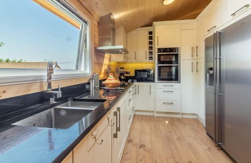 Stowmarket Cabina | La amplia sala de estar tiene un fabuloso ambiente hogareño con una estufa de leña contemporánea.