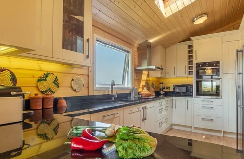 Stowmarket Cabina | La amplia sala de estar tiene un fabuloso ambiente hogareño con una estufa de leña contemporánea.