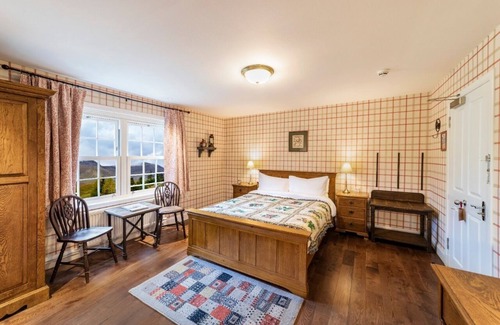 Shiel Bridge Cama Y Desayuno | The wooden floors, vintage furniture, and tartan accents create a comfy room