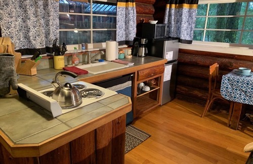 Ashford Cabina | This historic log cabin is adjacent to Copper Creek Restaurant just a few miles to Mt. Rainier National Park. Hot tub, full kitchen, gas fireplace, romance!