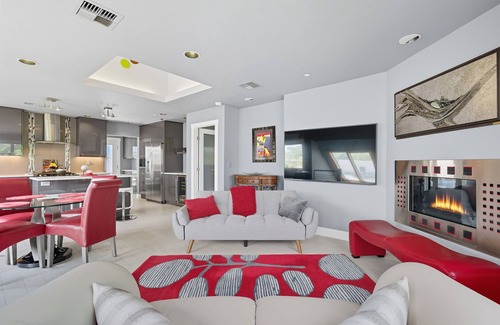 Hough Apartamento | Top-level duplex featuring a sleek open concept kitchen with stainless appliances, cozy fireplace, stylish furnishings, and in-unit washer/dryer. Designed for basking in the sun under skylights in thoughtful details throughout.