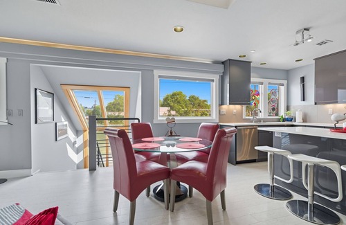 Hough Apartamento | Top-level duplex featuring a sleek open concept kitchen with stainless appliances, cozy fireplace, stylish furnishings, and in-unit washer/dryer. Designed for basking in the sun under skylights in thoughtful details throughout.