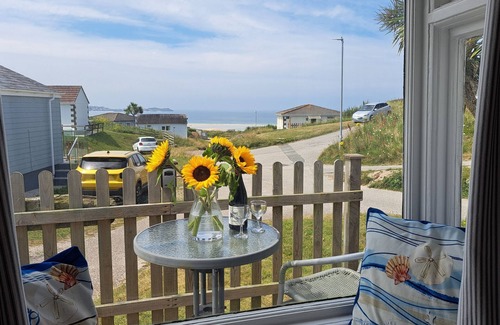 Hayle Chalet De Esquí | Treville soaks up the sun, which can be enjoyed from the deck with sea views.