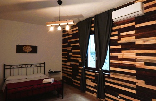 Piazza Armerina Cama Y Desayuno | Warm and cozy room with handcrafted recycled wood finishes