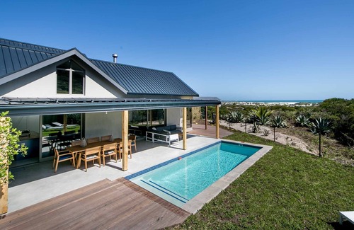 Noordhoek Villa | Willow Beach House a la derecha en las dunas de arena de la playa de Noordhoek largo