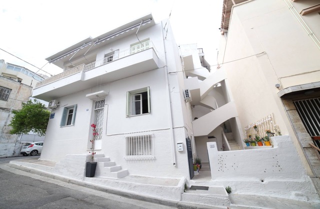 Una casa con un patio y un balcón, situado en la zona de Filopappou.