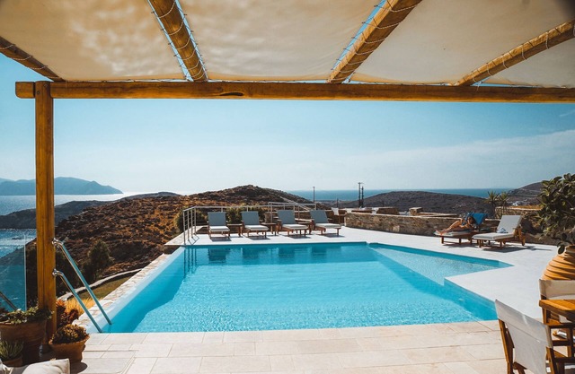Una elegante casa familiar con piscina infinita y vistas impresionantes al mar.
