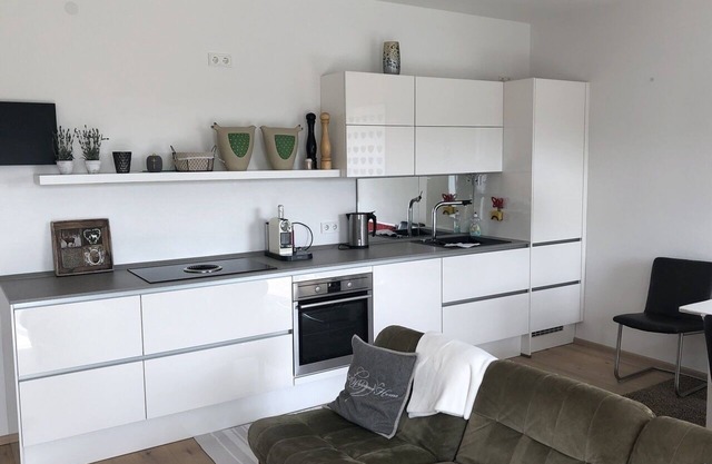 Apartamento con terraza de madera y ducha a ras de suelo para dos personas.