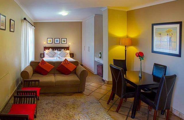 Habitación de huéspedes con cama doble y cocina, en Port Elizabeth ideal para viajes de negocios