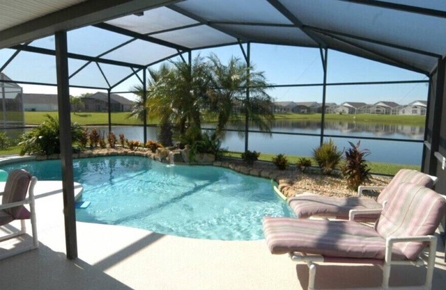 Piscina estilo laguna con bañera de hidromasaje y sala de juegos.
