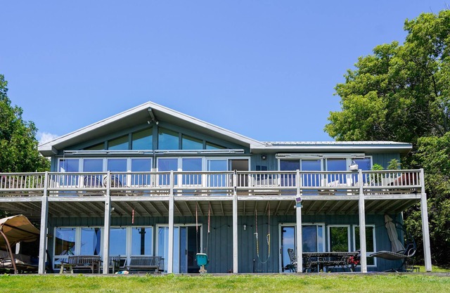 Lakefront home with fireplace, deck, patio, kayaks, and small beach