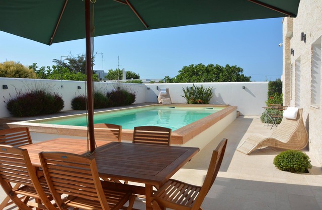 Villa moderna con piscina, vistas al mar y jardín mediterráneo.