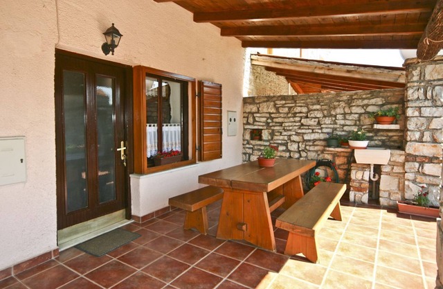 Casa rústica de piedra con parasol en una finca vallada