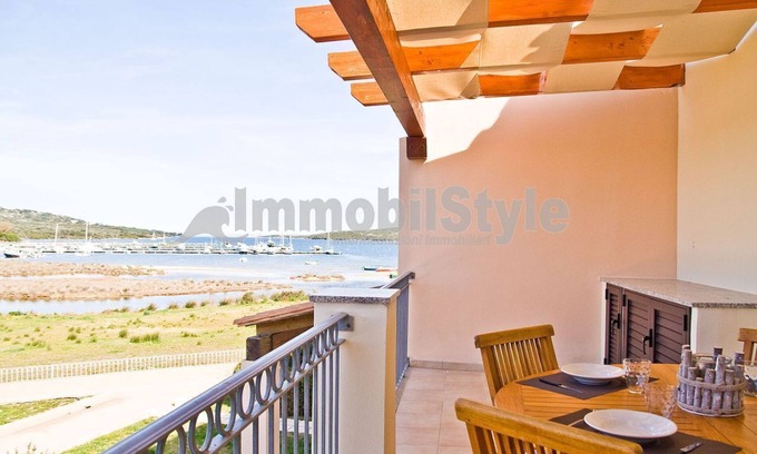 Porto Pozzo Apartamento | Apartamento con terraza y vistas al mar.