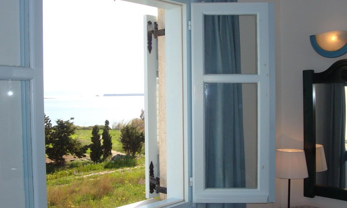 Drios Apartamento | habitación azul y mar con la cara de la ventana con vistas al mar