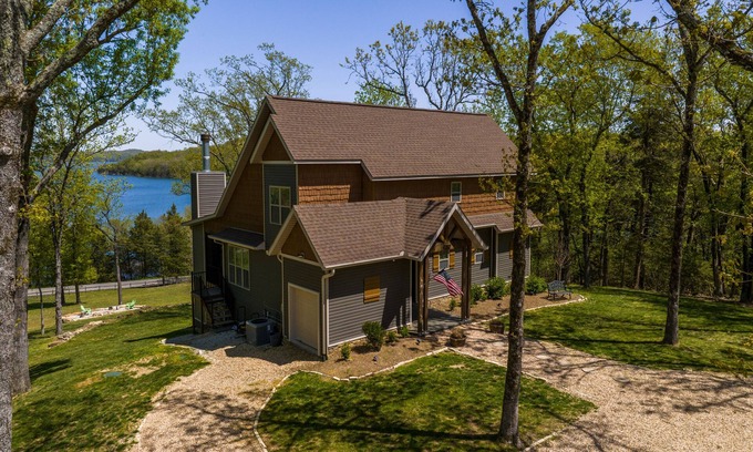 Rogers Casa | Elegant lakefront home with a fireplace, screened patio & lovely views