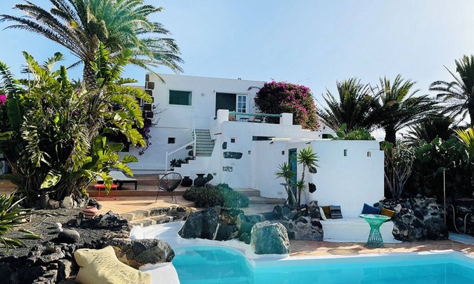 Teguise Casa | Oasis verde con piscina y vista a las montañas de fuego.