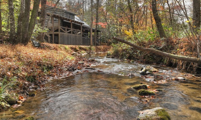 Dial Cabina | Indulge in "Just One More Night", a pet-friendly creekfront retreat boasting a spacious outdoor deck, hot tub, firepit, and WiFi