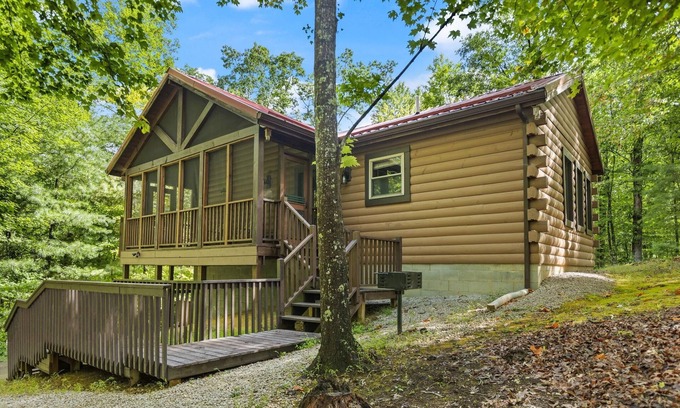 Zoe Cabina | Log Home with fenced in deck & screen porch, cosmopolitan style ranch design.