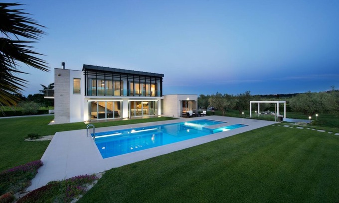 Frisa Villa | Villa moderna con piscina rodeada de vegetación.
