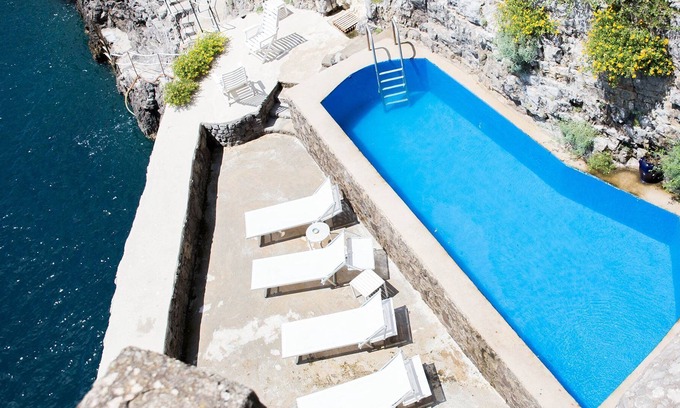 San Pietro Villa | Una torre en el mar con un embarcadero privado y una piscina de agua de mar.