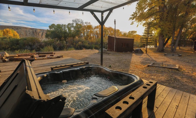 Dubois Cabina | Escape to a Deluxe Queen Room with Tranquil River Views and Breathtaking Mountain Backdrop.