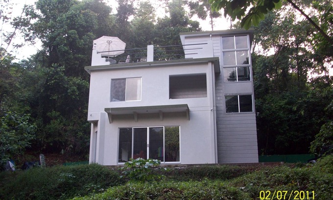 Portalón Casa | Casa de la selva privada con vista parcial al mar.