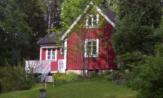 Vissefjaerda Casa | Red and white cottage with a boat not far from the lake